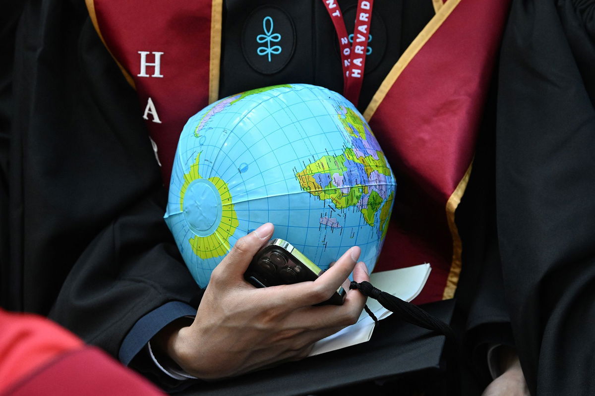 <i>Josh Reynolds/The Washington Post/Getty Images via CNN Newsource</i><br/>A graduate of the Kennedy School of Government carries an inflatable globe during commencement exercises at Harvard University on May 29 in Cambridge