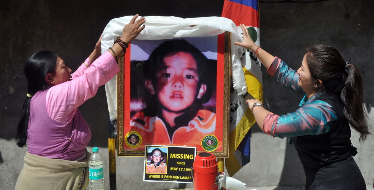 <i>Hindustan Times/Hindustan Times/Hindustan Times via Getty Images via CNN Newsource</i><br/>Two women place a ceremonial scarf above a portrait showing the last know image of Gedhun Choekyi Nyima