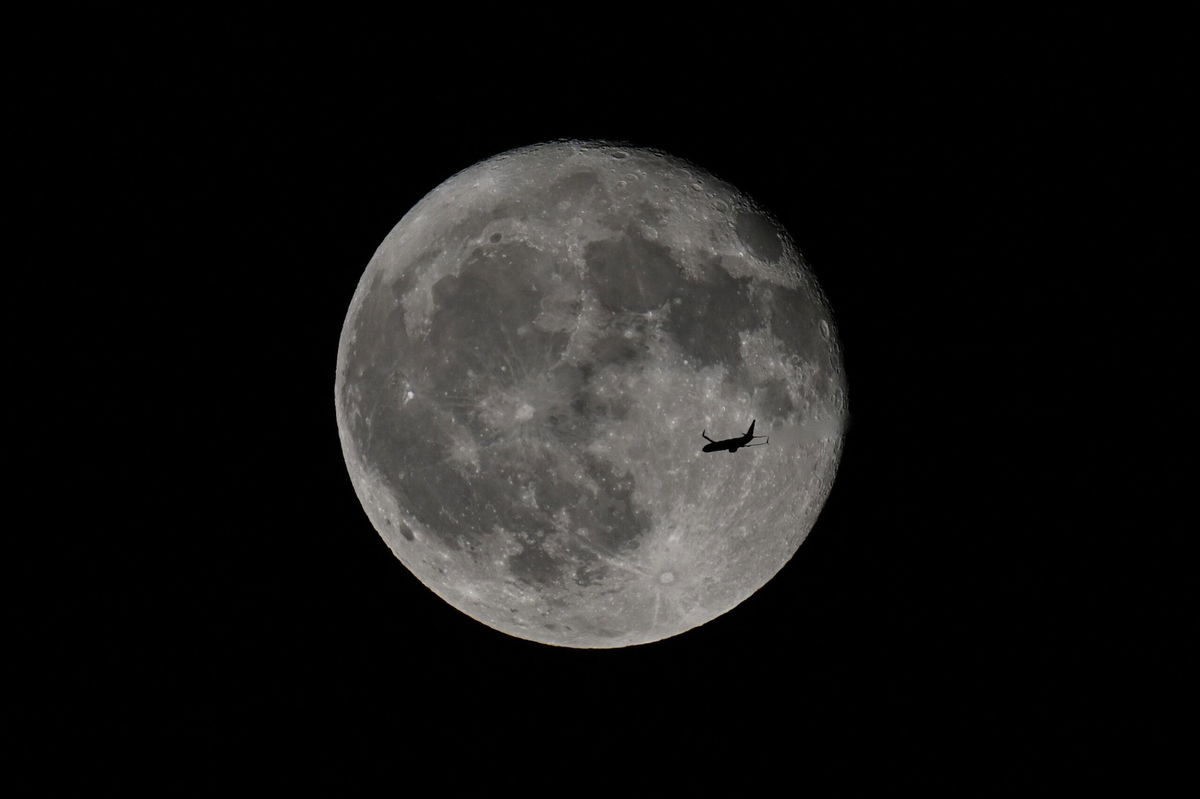 <i>Tayfun Coskun/Anadolu/Getty Images via CNN Newsource</i><br/>A passenger plane flies in front of the full strawberry moon over San Francisco Bay seen from Foster City in California in June 2024.