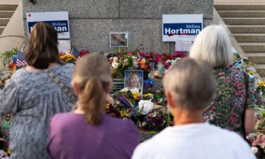 People look on at a memorial for Melissa and Mark Hortman during a candlelight vigil outside the state Capitol building in St. Paul