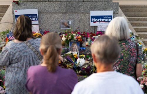 People look on at a memorial for Melissa and Mark Hortman during a candlelight vigil outside the state Capitol building in St. Paul