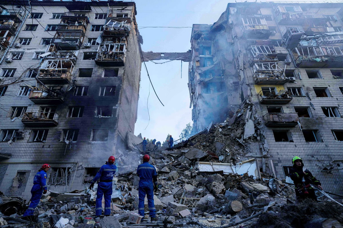 <i>Evgeniy Maloletka/AP via CNN Newsource</i><br/>Rescue workers clear the rubble of a multi-storey residential house destroyed by a Russian strike in Kyiv