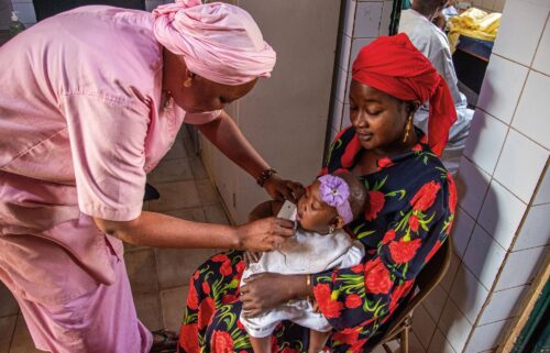 A nurse detects malnutrition in a baby using arm circumference measurement as part of ALIMA’s malnutrition project