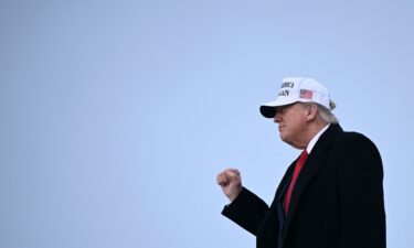 President Donald Trump raises a fist as he steps off of Air Force One upon arrival at Calgary International Airport