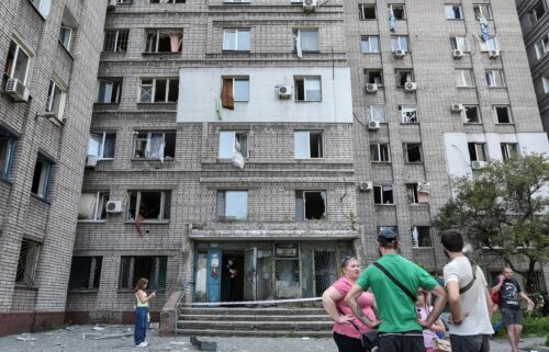Residents stand near an apartment building that was damaged during a Russian missile strike in Dnipro on June 24