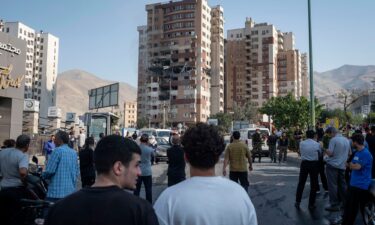 Iranian people gather at the scene of an explosion at a residential complex due to Israeli attacks in Tehran