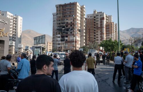 Iranian people gather at the scene of an explosion at a residential complex due to Israeli attacks in Tehran