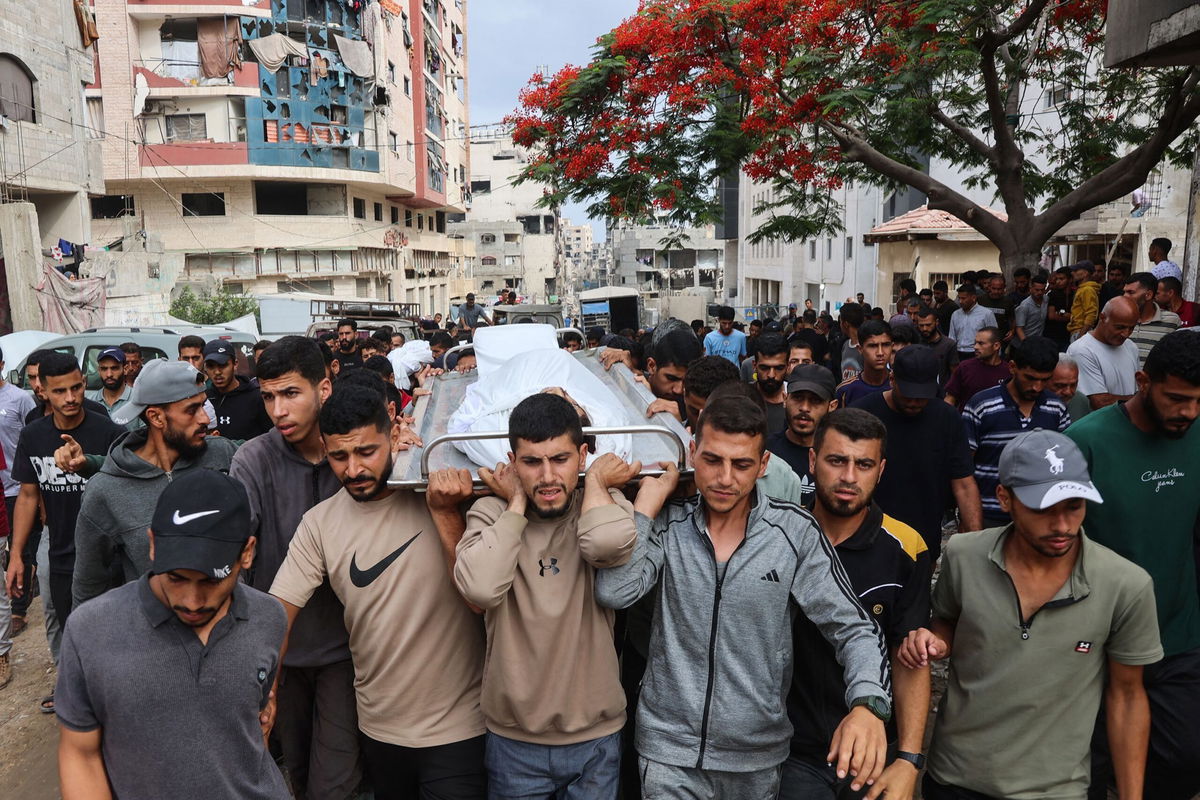 <i>Omar Al-Qattaa/AFP/Getty Images via CNN Newsource</i><br/>Palestinians carry the body of a man killed a day earlier while attempting to get aid at a distribution point near the Israeli-controlled Zikim border crossing