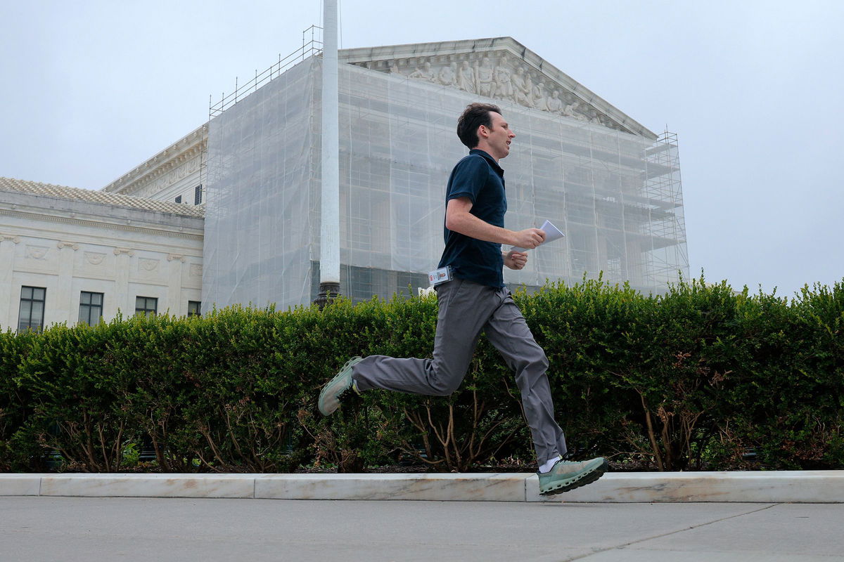 <i>Chip Somodevilla/Getty Images via CNN Newsource</i><br/>CNN's Max Rego runs out of the US Supreme Court building carrying an ruling during the last day of the court's term on June 27