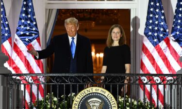 President Donald Trump gestures next to Judge Amy Coney Barrett on the Truman Balcony after she was sworn in as a US Supreme Court Associate Justice during a ceremony on the South Lawn of the White House October 26