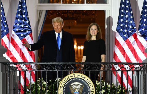 President Donald Trump gestures next to Judge Amy Coney Barrett on the Truman Balcony after she was sworn in as a US Supreme Court Associate Justice during a ceremony on the South Lawn of the White House October 26