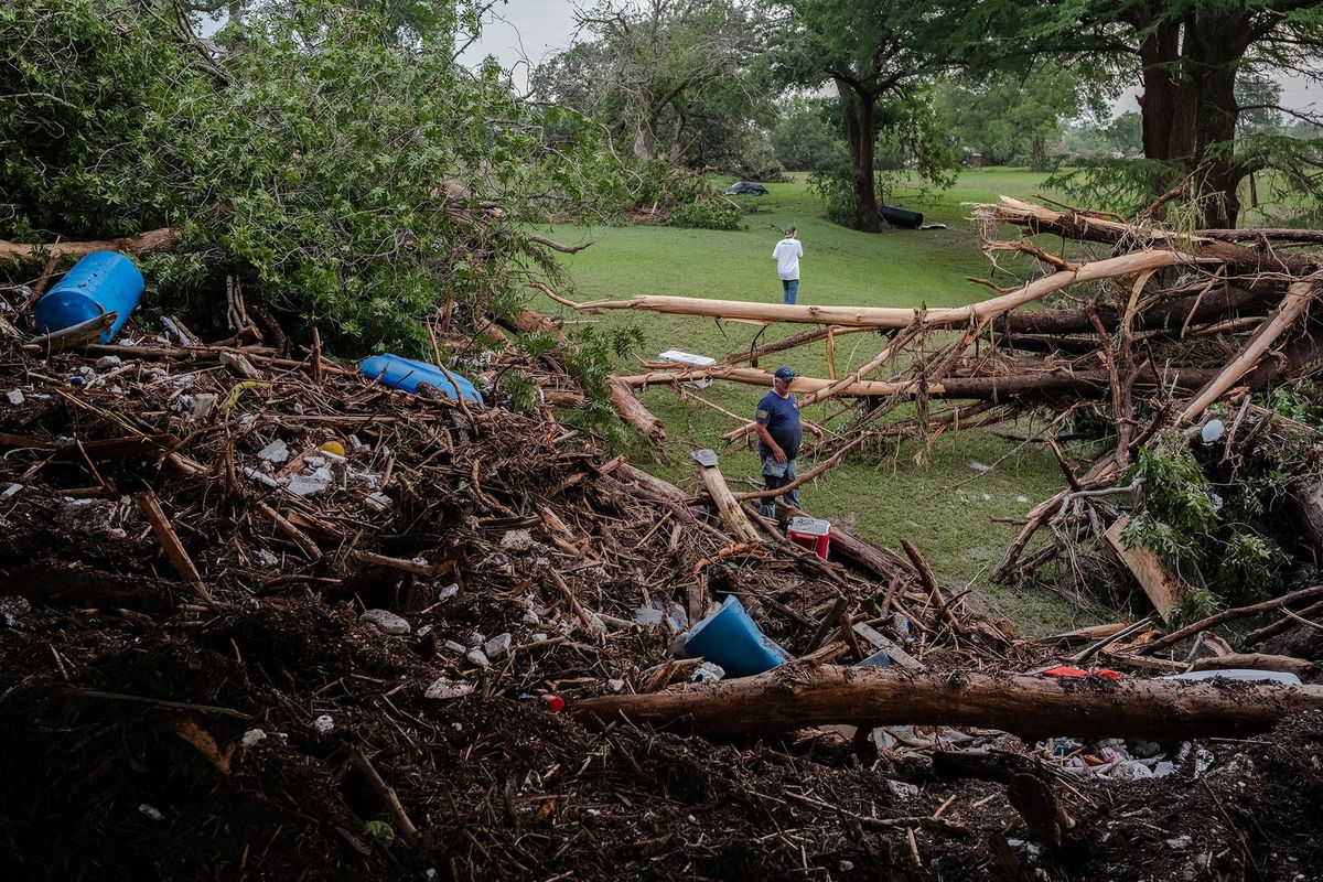 <i>Jim Vondruska/Getty Images via CNN Newsource</i><br/>Two men search for survivors after flash flooding on the bank Guadalupe River on July 5 in Center Point