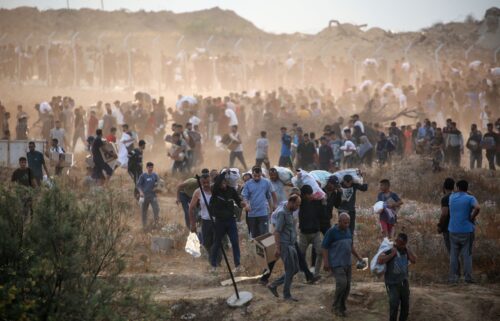 People carry relief supplies from a Gaza Humanitarian Foundation (GHF) aid distribution centre in the central Gaza Strip on June 8.