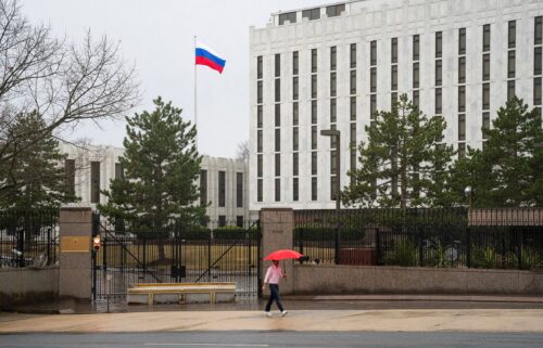 A pedestrian walks with an umbrella outside the Embassy of the Russian Federation