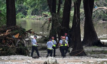 Members of a search and rescue team look for people near Camp Mystic