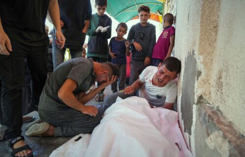Relatives mourn over the bodies of Manal Abd Rabbo and her sister Fatima