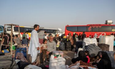 Afghans wait for shuttles and assistance at the overcrowded border reception area in Islam Qala