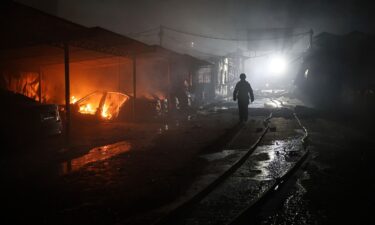 A rescue worker walks on a parking of car repair service destroyed by a Russian drone strike in Zaporizhzhia