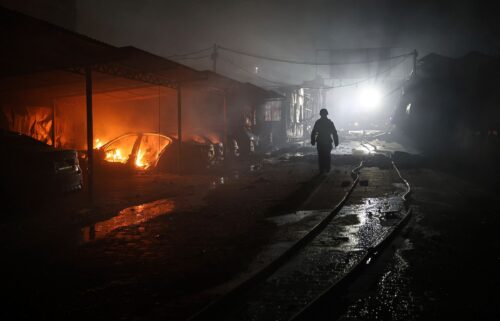 A rescue worker walks on a parking of car repair service destroyed by a Russian drone strike in Zaporizhzhia