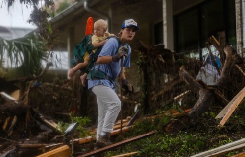 A search and rescue worker looks through debris for survivors or victims swept up in the flash flooding in Hunt