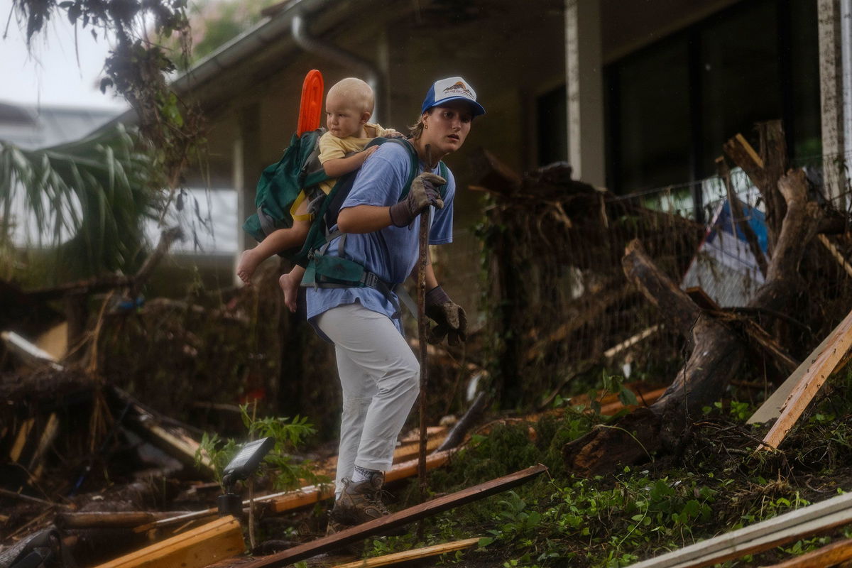 <i>Jim Vondruska/Getty Images via CNN Newsource</i><br/>A search and rescue worker looks through debris for survivors or victims swept up in the flash flooding in Hunt