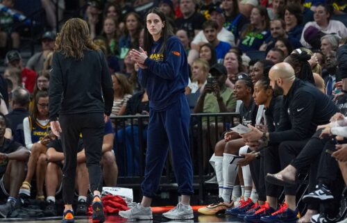 Injured Indiana Fever guard Caitlin Clark watches the final from the sideline.