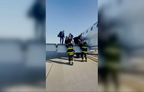 Passengers climb off the the wing of United Express flight 4423 after it made an emergency landing in St. Louis.
