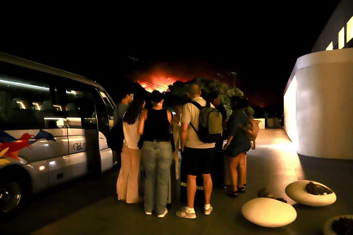 <i>Nikos Chalkiadakis/EPA/Shutterstock via CNN Newsource</i><br/>Tourists evacuate a hotel on Crete as wildfires burn.