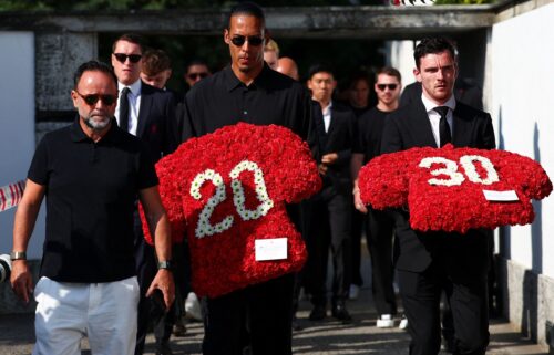 Liverpool captain Virgil van Dijk and left-back Andy Robertson arrive to the funeral with flowers on Saturday morning.