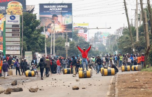 A demonstrator stands on a barricade cylinder during clashes with riot police in Nairobi on July 7.