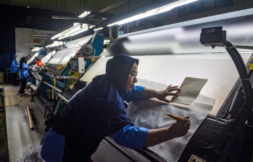 A worker inspects fabric for export before the dyeing process at the Trisula Textile Industries factory in Cimahi
