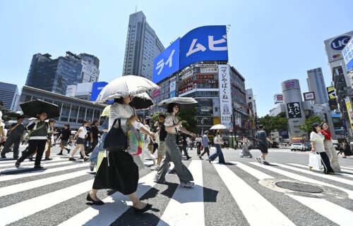 People cross the iconic Shibuya crossroads on June 17 in Tokyo