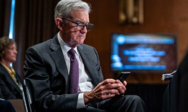 Federal Reserve Chair Jerome Powell looks at a phone during a Senate Banking
