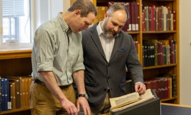 Study coauthors Dr. James Wade (left) and Dr. Seb Falk study the sermon mentioning the Song of Wade.