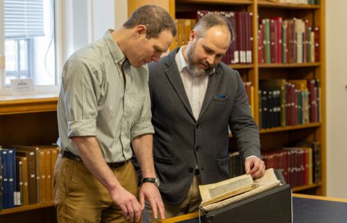 Study coauthors Dr. James Wade (left) and Dr. Seb Falk study the sermon mentioning the Song of Wade.