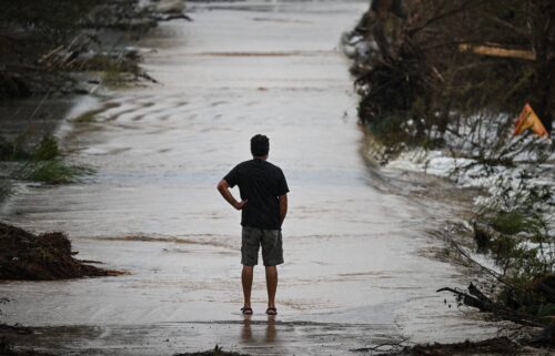 A man looks at a damaged road after severe flash flooding that occurred during the July 4 holiday weekend