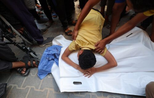 A boy leans over the body of his cousin after he was killed in an Israeli strike that hit Nuseirat in central Gaza on July 13.