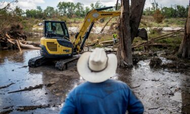Machinery is used to clear debris along the banks of the Guadalupe River after catastrophic floods in Center Point