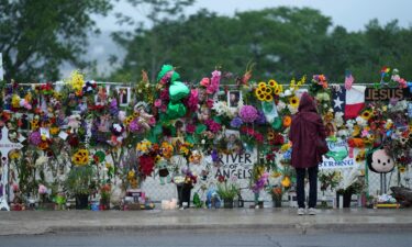A visitor views a memorial wall for flood victims