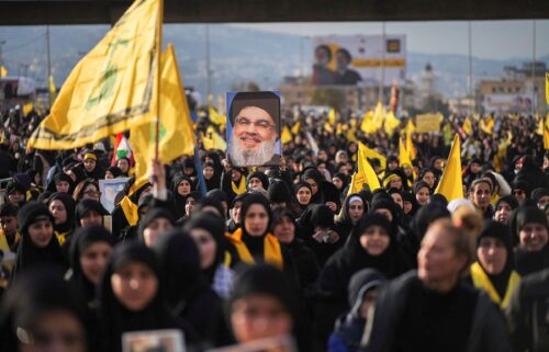A person holds up a picture of late Hezbollah leader Hassan Nasrallah