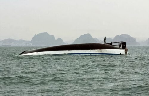 People stand on a tourist boat that capsized in Halong Bay on July 19.