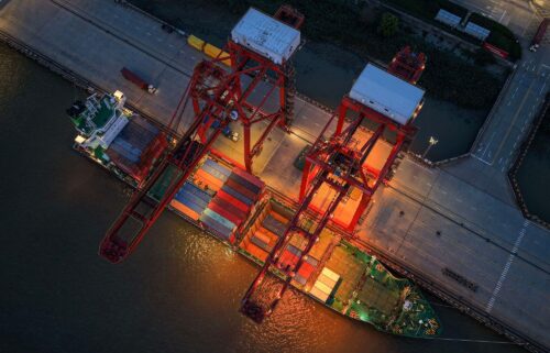 Cranes unload shipping containers from a ship at a port in Nanjing