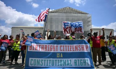 People hold a banner as they participate in a protest outside the US Supreme Court over President Donald Trump's move to end birthright citizenship as the court hears arguments over the order in Washington