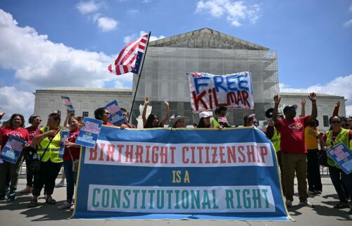 People hold a banner as they participate in a protest outside the US Supreme Court over President Donald Trump's move to end birthright citizenship as the court hears arguments over the order in Washington
