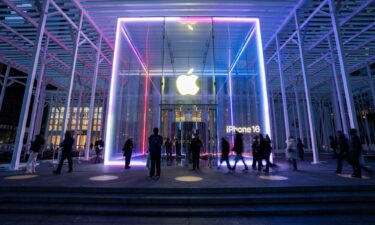 People walk by the Apple Store on Fifth Avenue on February 24 in New York City. Apple is investing another $100 billion to expand its operations in the United States