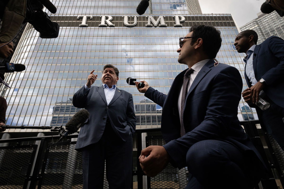 <i>Scott Olson/Getty Images via CNN Newsource</i><br/>Illinois Gov. JB Pritzker speaks to the press while on board a water taxi passing Trump Tower on the Chicago River on August 25