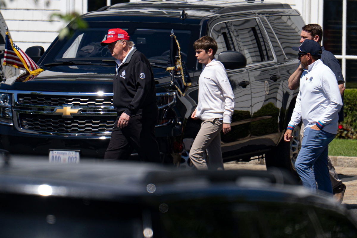 <i>Kayla Bartkowski/Getty Images via CNN Newsource</i><br/>President Donald Trump walks with his grandchild Spencer Trump after golfing at Trump National Golf Club in Sterling
