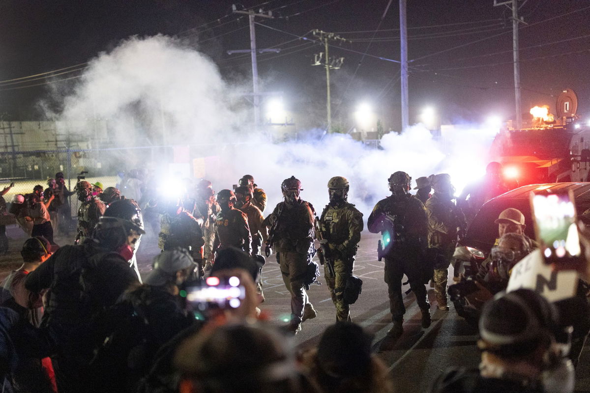 <i>Scott Olson/Getty Images via CNN Newsource</i><br/>Federal law enforcement agents stand off against demonstrators protesting outside of an immigrant processing center on September 27