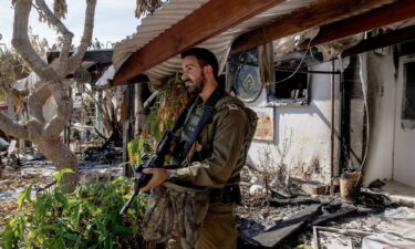 A soldier inspects a burnt out home at kibbutz Nir Oz on October 30