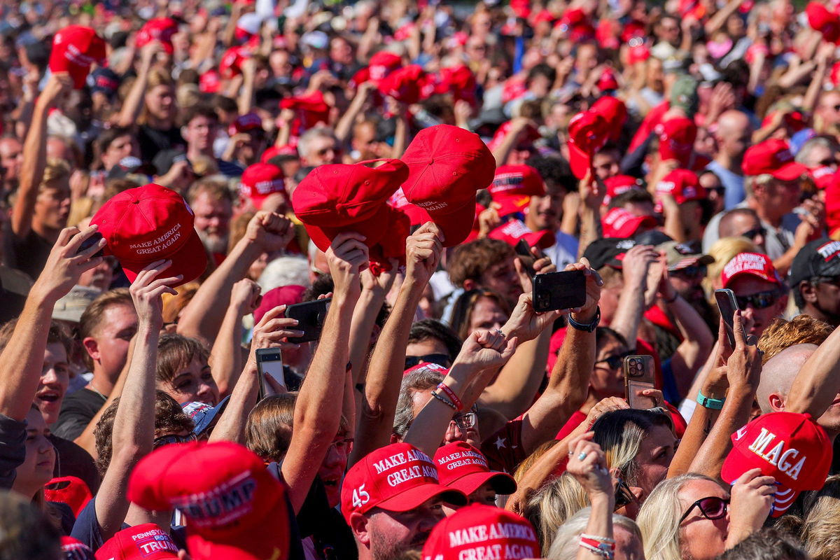 <i>Brian Snyder/Reuters via CNN Newsource</i><br/>Supporters of Donald Trump raise MAGA hats in Butler